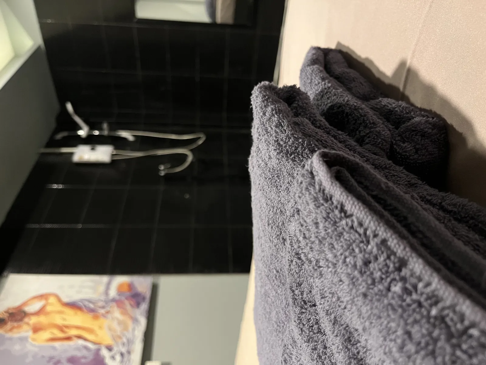 Folded grey spa towels prepared in a private suite at Heal nuru massage studio, Bangkok.